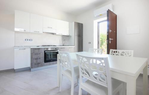 a white kitchen with a white table and chairs at Gorgeous Home In Casalvelino With Wifi in Casal Velino