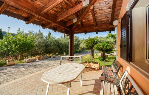 a patio with a wooden table and two benches at 4 Bedroom Cozy Home In Ragusa in Ragusa