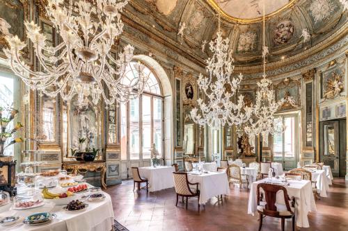 a dining room with white tables and chandeliers at Palazzo Doria Napoli in Naples