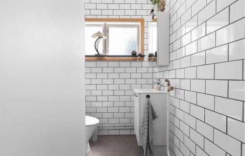 a white bathroom with a toilet and a window at 3 Bedroom Awesome Home In Lessebo in Lessebo