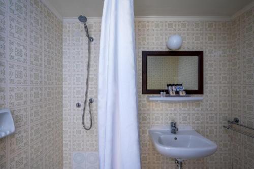 a bathroom with a sink and a shower with a mirror at Elafos Hotel in Sálakos