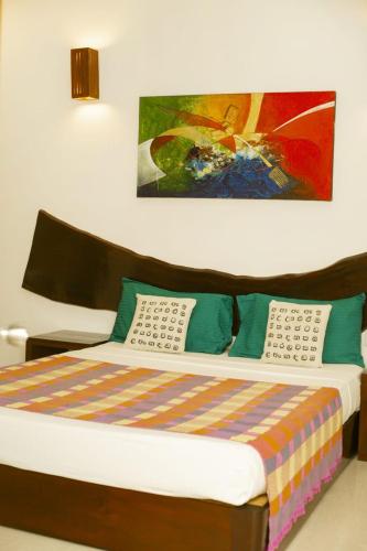 a bed in a room with a painting on the wall at The Classic-hostel-apt-deluxe in Weligama