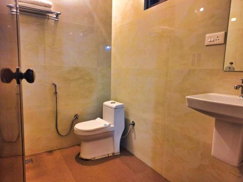 a bathroom with a toilet and a sink at Comfort Cove in Vythiri