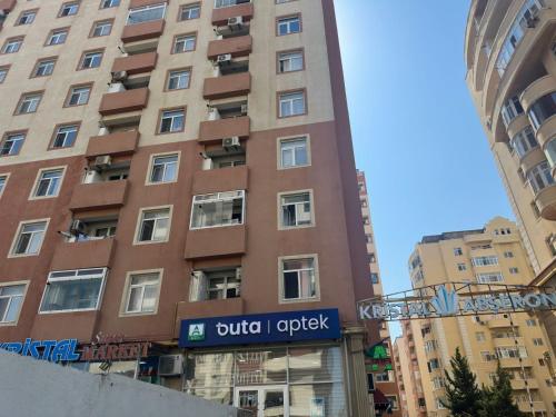 a tall building with a sign in front of it at Kvartira s vidom na more in Sumqayyt