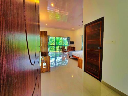 a bedroom with a bed and a room with a door at Comfort Cove in Vythiri