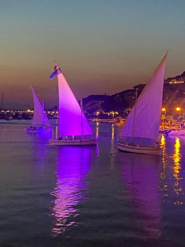 three sailboats floating in the water at night at Rooms Perina Tisno in Tisno