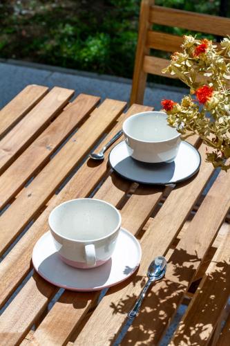 two bowls and spoons sitting on a wooden table at BBQ Terrace Balaton 2BR Apt by NW in Balatonszárszó