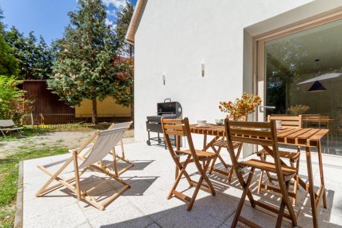 a wooden table and chairs on a patio at BBQ Terrace Balaton 2BR Apt by NW in Balatonszárszó