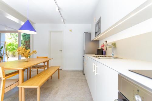 a kitchen with white counters and a wooden table at BBQ Terrace Balaton 2BR Apt by NW in Balatonszárszó
