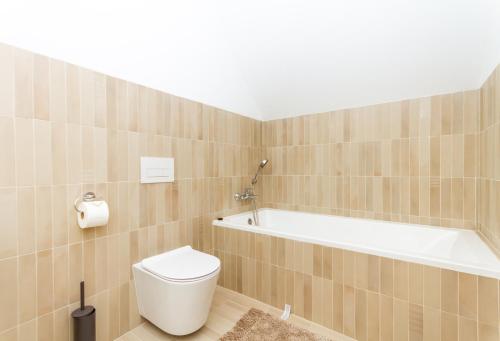 a bathroom with a toilet and a bath tub at BBQ Terrace Balaton 2BR Apt by NW in Balatonszárszó