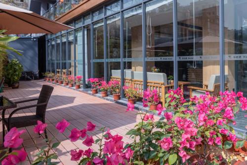 a row of flowers on a patio in front of a building at Leader Art Hotel（Shenzhen University Science and Technology Park Store)） in Shenzhen