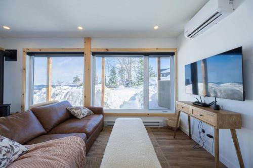 a living room with a couch and a large window at Ski Chalet with Spa - Mountain - La Boheme in Saint Come