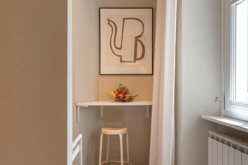 a stool in a hallway with a shelf and a picture at Grapeful Stay - Canelli center - 8 pax - free park in Canelli