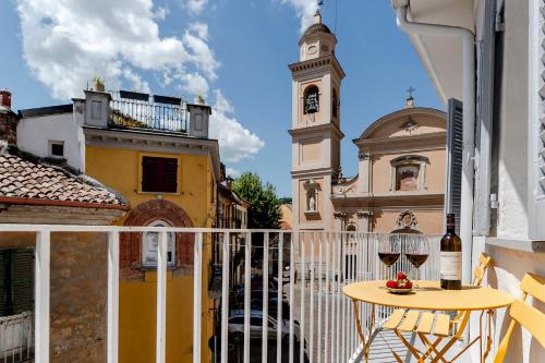 a balcony with a table and a clock tower at Grapeful Stay - Canelli center - 8 pax - free park in Canelli