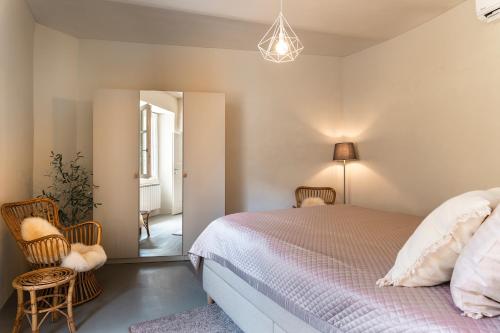 a bedroom with a bed and two chairs and a mirror at Grapeful Stay - Canelli center - 8 pax - free park in Canelli