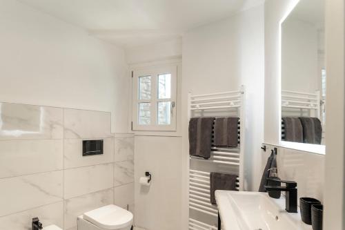 a white bathroom with a toilet and a sink at Grapeful Stay - Canelli center - 8 pax - free park in Canelli