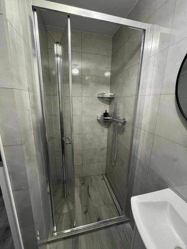 a shower with a glass door next to a sink at Zatoka Stegna in Stegna