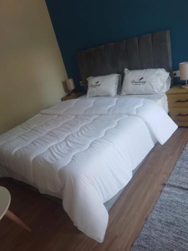 a large white bed with white sheets and pillows at MDE Loisir Tanjis m in Tangier