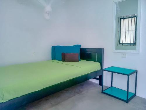 a bedroom with a bed and a side table at The Classic-hostel-apt-deluxe in Weligama