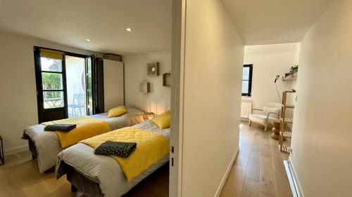 a bedroom with two beds with yellow sheets at Hozanna chic & charme in Le Crotoy