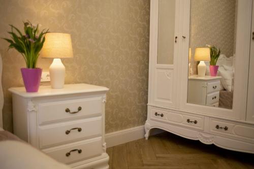 a bedroom with a white dresser and a mirror at Chillinn La Maison Cottage Eger in Eger