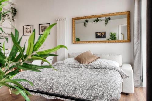 une chambre avec un lit et un miroir dans l'établissement Castrelli Loft Rho-Fiera Milano, à Rho
