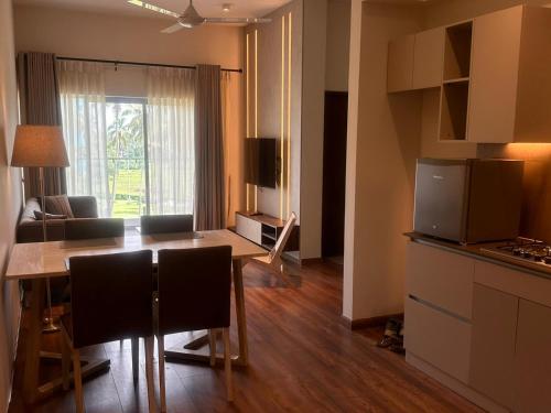 a kitchen and living room with a table and chairs at Canterbury Golf Apartment in Gonapola