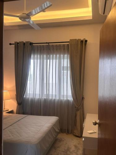 a bedroom with a bed and a window with curtains at Canterbury Golf Apartment in Gonapola