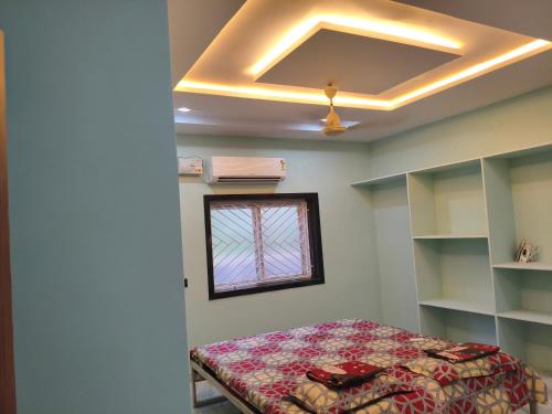 a bedroom with a bed and a window at Sri padha vallabha badi Home stay in Pithāpuram