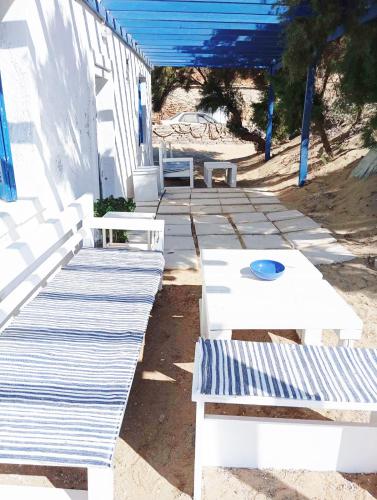 a row of white benches on the beach at Ateni Beachfront in Aténi