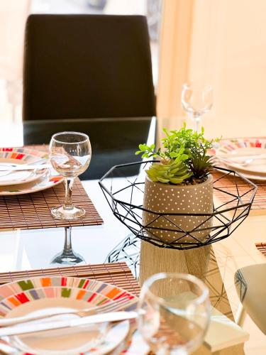 a table with plates and glasses and a plant in a basket at Villa Merope Irena 1 in Polis Chrysochous