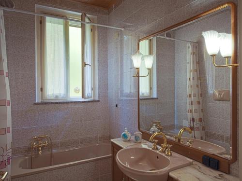 y baño con lavabo, bañera y espejo. en Il Gattopardo, en Cividale del Friuli