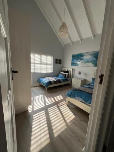 a bedroom with two beds and a window at Stoneridge Large Family Cottage in Plettenberg Bay