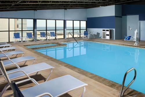 a large swimming pool with chairs and tables at Four Points by Sheraton Virginia Beach Oceanfront in Virginia Beach