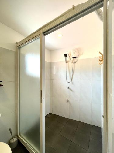 a shower with a glass door in a bathroom at Chill Out Hostel in Boracay