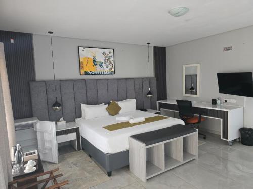 a bedroom with a large white bed and a desk at Tlokweng Rose Garden Guesthouse in Gaborone