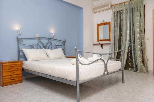 - une chambre bleue avec un lit et un miroir dans l'établissement John's economy, à Naxos Chora