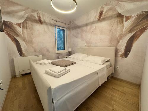 Un dormitorio con una cama grande con sábanas blancas. en Apartment Del Mar, en Novi Vinodolski