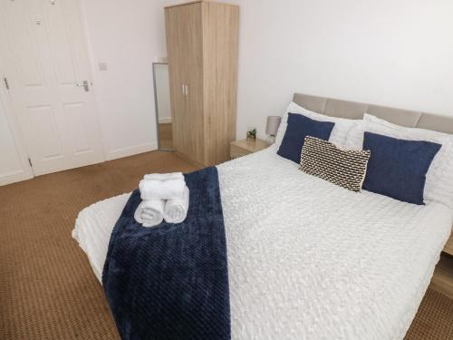 a bedroom with a large bed with towels on it at Curwen Apartment in Workington