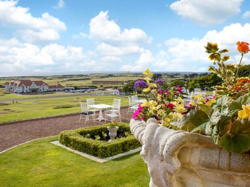 a garden with tables and chairs and flowers on a hill at Royal Aberdeen - Ukc6917 in Turnberry