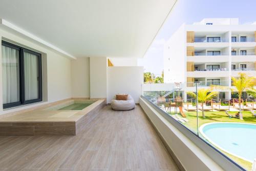 プンタ・カナにあるBrand New 2BR Stylish Apartment in the Heart of Punta Cana, Gardenia Gated Communityのプールと建物のある空のリビングルーム