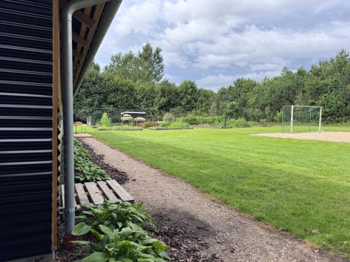 a bench sitting next to a field of grass at Pension Lærkelill in Skovlund