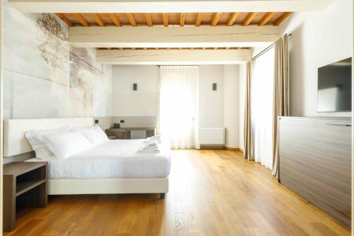 a bedroom with a white bed and a large window at Villa Roncuzzi 