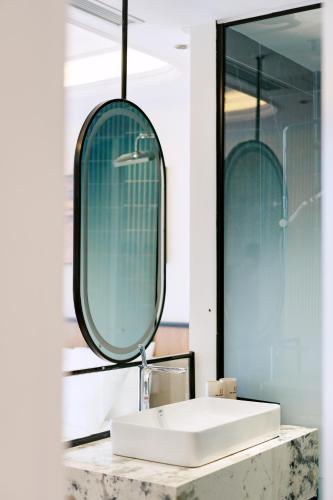 a bathroom with a sink and a mirror at HN Apartment and Hotel in Tài Xá