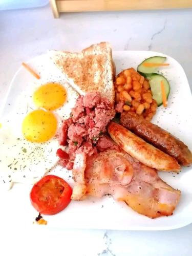 a plate of breakfast food with eggs sausage and toast at Tlokweng Rose Garden Guesthouse in Gaborone