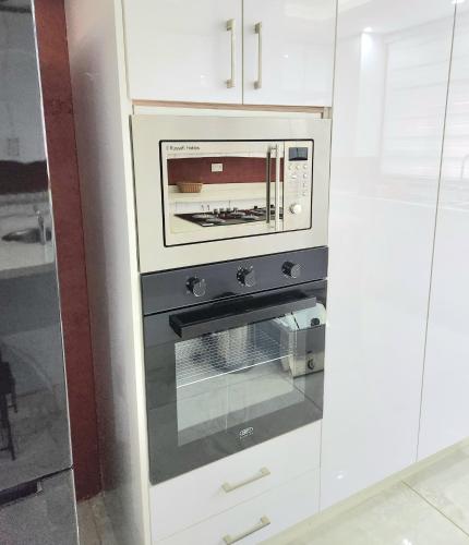 a kitchen with an oven in a white kitchen at Tlokweng Rose Garden Guesthouse in Gaborone