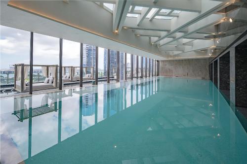 a swimming pool with a view of a building at Conrad Shenzhen, the first art museum hotel in Greater Bay Area with the stunning bay and sunset view in the hotel terrace in Shenzhen