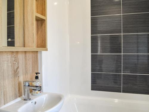 a bathroom with a sink and a glass shower at Gill Bay - Uk45513 in Mainsriddle