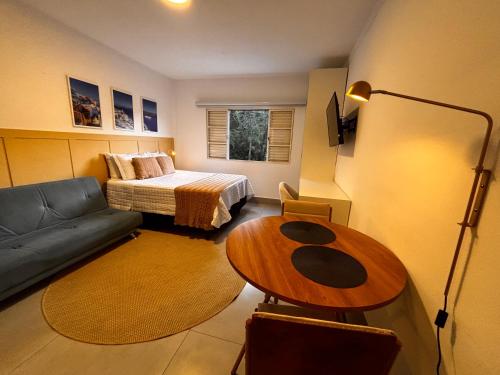 Camera piccola con letto, divano e tavolo. di Apart Grécia l Aconchego nas Montanhas l Águas de Lindóia ad Águas de Lindóia