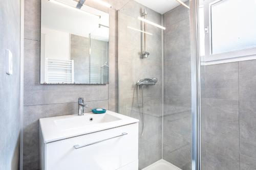 a bathroom with a white sink and a shower at Maison avec Jardin proche Océan in Saint-Denis-dʼOléron